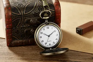 Detailansicht einer antiken Bronze-Quarztaschenuhr mit offenem Deckel und Zifferblatt.