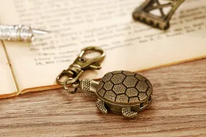 Vintage Bronze Schildkröte Taschenuhr Schlüsselanhänger auf rustikalem Holztisch