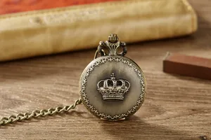 Detailansicht einer antiken Bronze-Quarztaschenuhr mit Kronenrelief und Kette