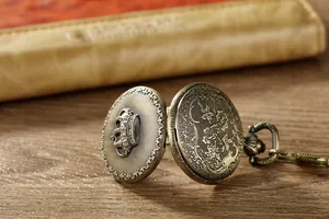 Makroaufnahme einer antiken Bronze-Quarztaschenuhr mit geprägtem Kronen-Design