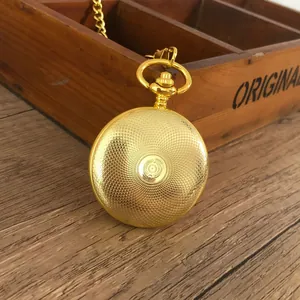 Detailansicht der Rückseite einer gravierten goldenen Vintage-Taschenuhr-Halskette auf Holz