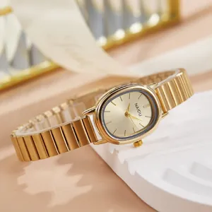 Élégante montre femme ovale dorée avec bracelet en acier style bambou exposée.