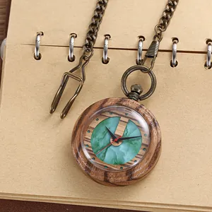 Detailed close-up of vintage wooden pocket watch with green marble dial and bronze chain