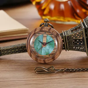 Close-up of vintage wooden pocket watch with green marble dial leaning on Eiffel Tower