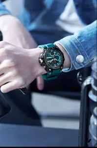 SMAEL sports watch with green silicone strap shown on a male wrist with denim jacket.