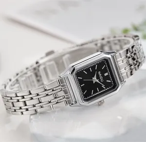Detalle de reloj cuadrado de acero inoxidable plateado con esfera negra