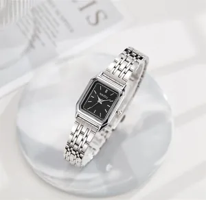 Detalle de primer plano de un elegante reloj cuadrado de acero plateado con esfera negra
