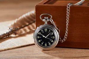 Détail d'une montre de poche vintage avec cadran lumineux noir et chaîne argentée.