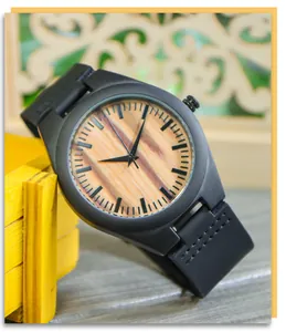 Gros plan d'une montre homme minimaliste avec cadran en bois et bracelet en cuir noir