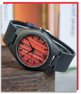 Vue détaillée du cadran en bois à rayures rouges et du bracelet noir de cette montre pour homme.