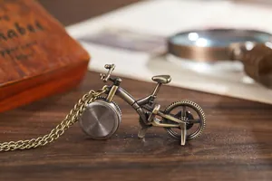Makroaufnahme einer antiken bronzefarbenen Fahrradtaschenuhr auf einem Holztisch.