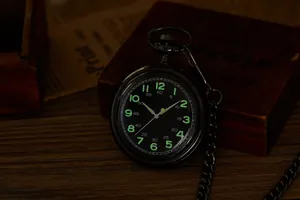 Vue macro d'une montre à gousset noire vintage avec chiffres du cadran lumineux verts
