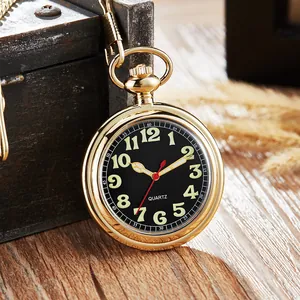Gros plan d'une montre à gousset vintage en or avec cadran noir et chiffres lumineux