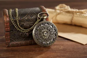 Makroaufnahme einer alten Bronze-Taschenuhr mit einem filigranen hohlen Blumenmuster