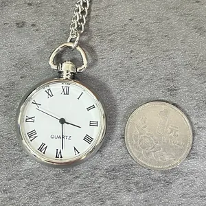 Reloj de bolsillo vintage de cuarzo plateado con números romanos y una moneda
