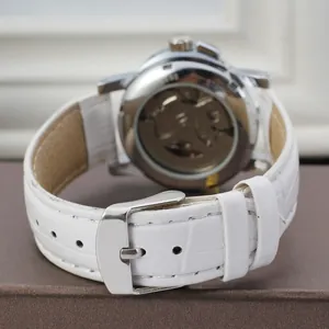 Detail view of Winner women's mechanical watch with white leather strap and transparent back.