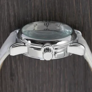 Detail showing the winding crown and side profile of a silver automatic watch case