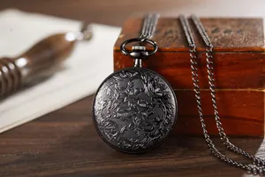 Detailed macro shot of vintage black embossed pocket watch with intricate floral patterns