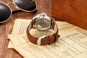 Vue arrière d'une montre automatique pour homme avec mouvement squelette sur papier vintage