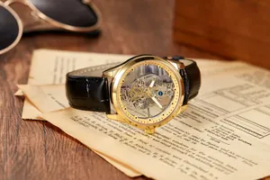 Montre mécanique squelette de luxe avec boîtier doré et bracelet cuir noir sur papier vintage