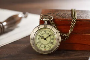 Detailed close-up of a vintage bronze quartz pocket watch with Roman numerals on a wooden box