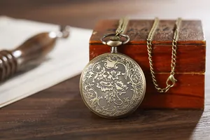 Detailed view of a vintage bronze pocket watch with an intricate floral relief pattern.