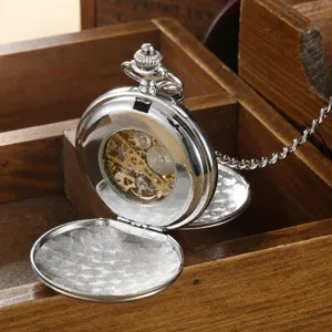 Close-up of vintage silver mechanical pocket watch with hollow gear mechanism and flip cover