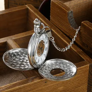 Detail view of silver vintage mechanical pocket watch with hollow floral cover