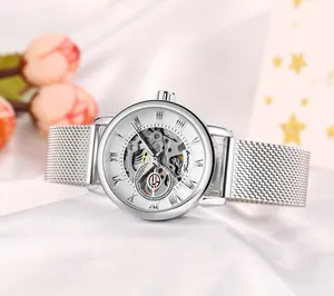 Elegant silver Forsining skeleton mechanical watch with stainless steel mesh strap on white silk