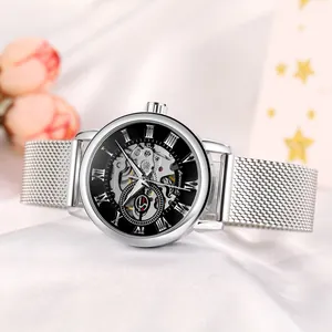 Close-up of silver Forsining skeleton mechanical watch with mesh strap on silk background.