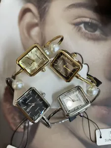 Dettaglio di orologi al quarzo quadrati vintage con eleganti cinturini rigidi con perle