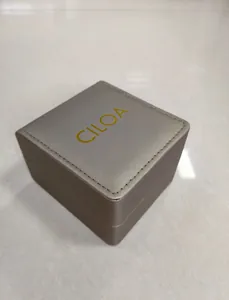 Elegante silbergraue Schmuck-Uhrenbox im Detail mit goldenem CILOA-Logo-Branding