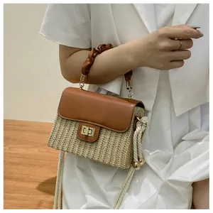 Detailansicht einer kleinen Strohtasche mit plissiertem Griff und Metallschloss