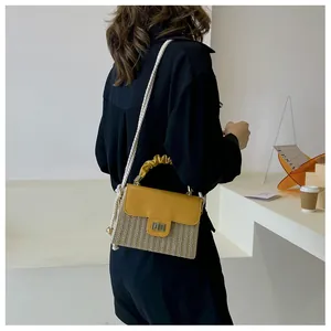 Elegante Stroh-Box-Tasche mit gelber Lederklappe und gerafftem Griff am Modell