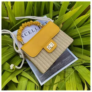 Detailansicht der gewebten Strohbox-Tasche mit gelber Lederklappe und goldenem Schloss