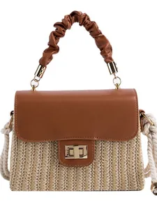 Handgewebte Strohtasche mit brauner Lederklappe und gerafftem Griff für Strand und Freizeit.