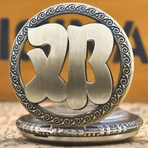 Macro view of vintage bronze pocket watch featuring an artistic hollowed-out surname design