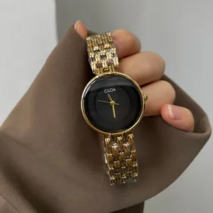 Gros plan sur la montre CILOA vintage pour femme avec bracelet doré et cadran noir épuré