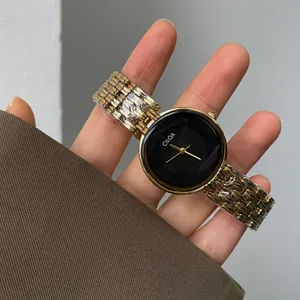 Gros plan d'une montre vintage CILOA en or pour femme avec cadran noir et bracelet métal