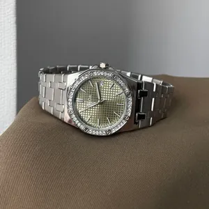 Elegante silberne Damenuhr mit Diamantlünette und strukturiertem goldfarbenem Zifferblatt