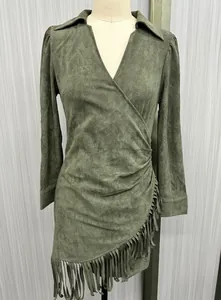 Close-up detail of western style green faux suede long sleeve dress with fringe tassels