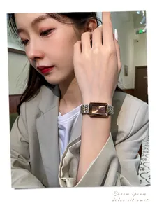 Close-up of elegant rectangular rose gold watch with faceted crystal on woman's wrist