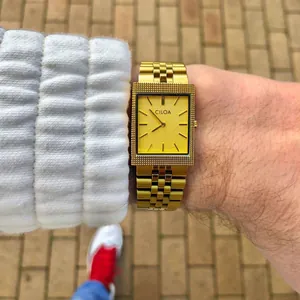 Détail de la montre rétro de luxe CILOA dorée portée au poignet d'un homme en extérieur