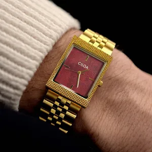 Vue détaillée de la montre carrée de luxe CILOA pour homme avec bracelet doré et cadran rouge