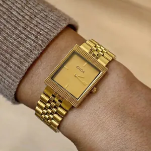 Élégante montre-bracelet carrée CILOA dorée pour homme présentée sur un poignet