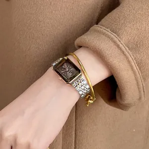 Elegant CILOA rectangular women's watch with bicolor metal strap on camel coat background