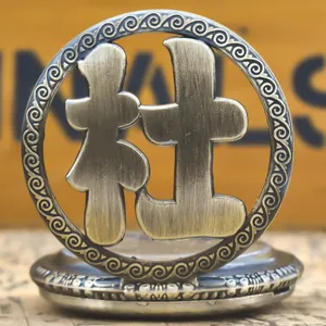 Close-up of vintage bronze pocket watch featuring the Chinese surname 'Du' hollow design