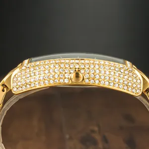 Detail shot of the side profile of a gold tonneau watch with iced out crystals