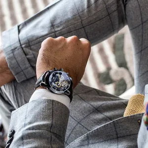 Gros plan d'une montre automatique Forsining au poignet d'un homme en costume écossais