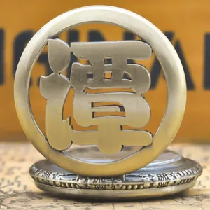 Detail of a vintage bronze-tone pocket watch with a hollowed Chinese surname Tan design.